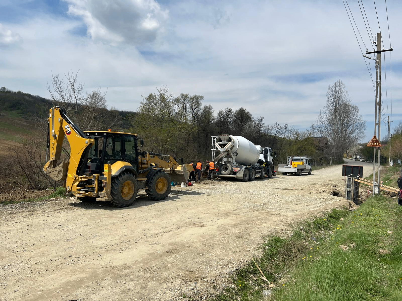 Autobetonieră și buldoexcavator CAT — turnare structură